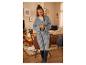 Une femme porte une cardigan en laine grise dans un décor chaleureux.