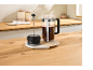 Cafetière à piston et mousseur à lait sur un plan de travail en bois.