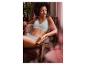Femme en soutien-gorge et culotte bleu clair, assise dans un fauteuil.