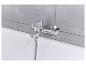 Robinet de baignoire chromé avec douchette, installé sur carrelage gris.