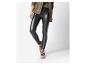 Femme portant un legging noir en cuir et des baskets gris clair.