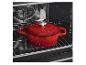 Cocotte en fonte émaillée rouge dans un four.