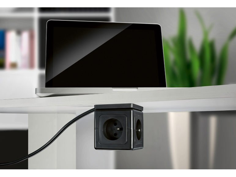 Ordinateur portable sur un bureau avec multiprise Tronic sous le plateau.