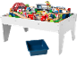 Ensemble de train en bois sur une table de jeu blanche avec une boîte de rangement bleue en dessous.