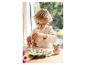 Enfant peignant des figurines de Pâques en céramique à table.