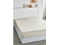 Un lit avec un drap-housse de couleur claire, décor minimaliste sur une étagère au-dessus.