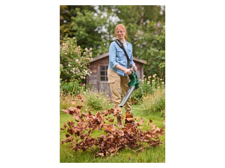 Femme utilisant un aspirateur-souffleur de feuilles sans fil PARKSIDE 40 V dans un jardin