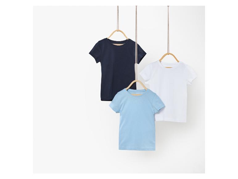 Trois t-shirts pour enfant : blanc, bleu clair et bleu marine.