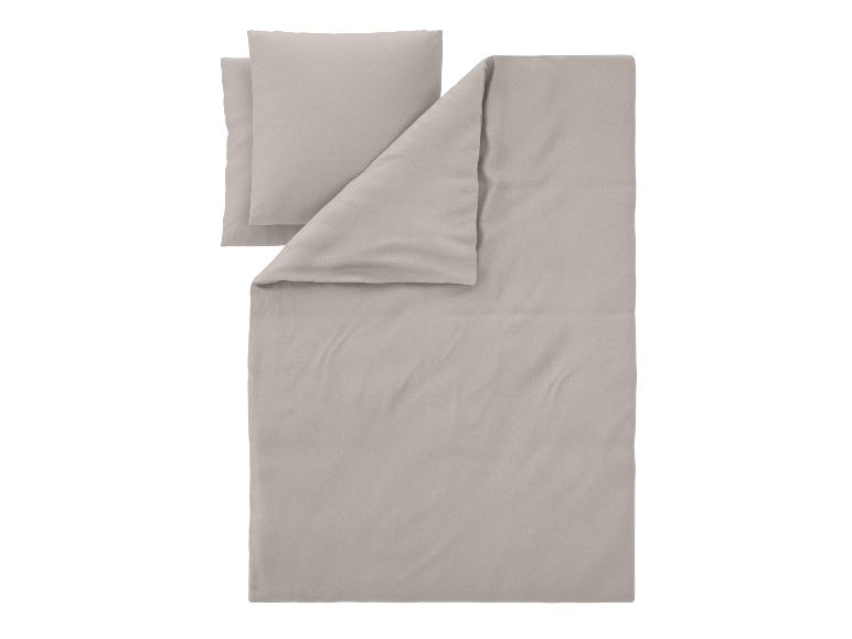 Parure de lit beige avec une housse de couette et deux oreillers.