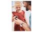 Petite fille en robe rouge regardant des coquillages avec son père.