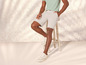 Un homme portant un short clair et des baskets blanches.
