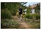 Un homme court en trail dans des vêtements et des chaussures Salomon.