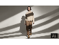 Une femme en pull à col roulé beige et pantalon marron marchant dans un studio aux ombres graphiques