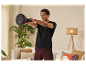 Un homme s'entraîne avec un kettlebell à la maison.