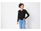 Une femme portant un pull noir et un jean bleu.