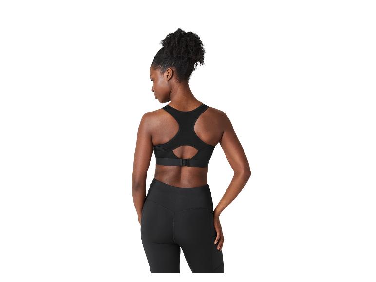 Femme de dos en brassière de sport noire et leggings.