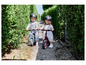 Deux enfants font du vélo d'équilibre Hudora, bleu et rouge.