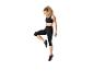 Femme en brassière de sport noire et legging capri faisant un exercice d'équilibre.