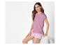 Une femme portant un t-shirt rose et un pantalon de pyjama rayé.