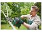 Un homme utilise une tronçonneuse Parkside pour couper une branche d'arbre.