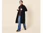 Femme en manteau noir, pull marron et jean.