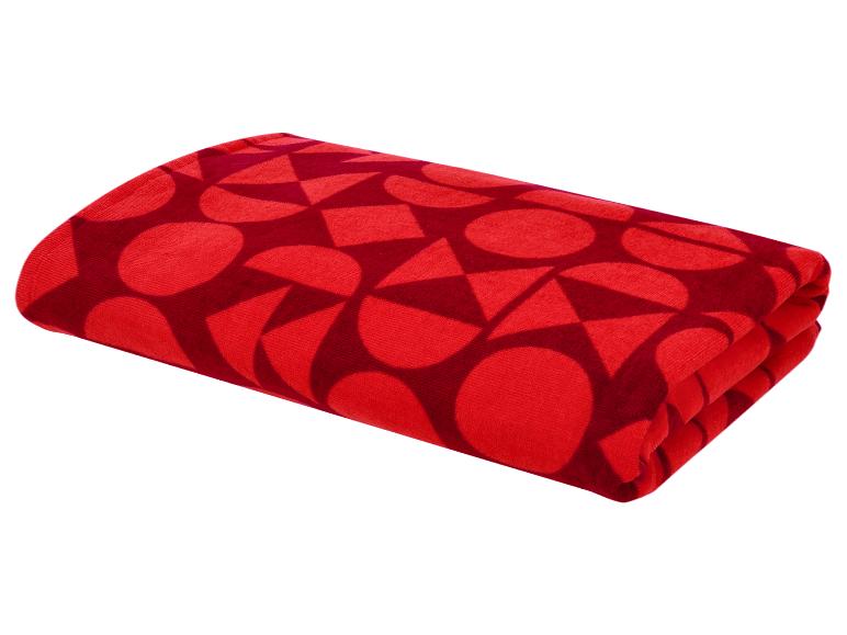 Couverture rouge pliée avec motif géométrique.
