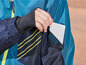 Une veste bleue avec une manche noire et une carte blanche dans la poche.
