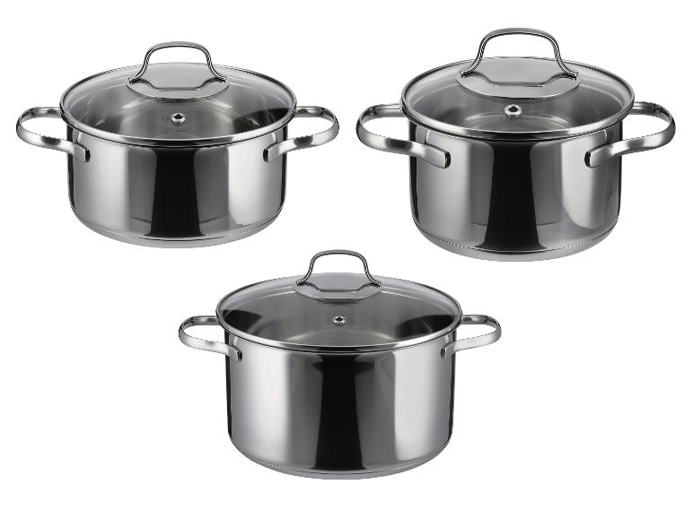 Trois casseroles en acier inoxydable avec couvercles en verre, sur fond blanc