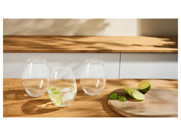 Trois verres en verre avec citron vert, menthe et glace sur une table en bois.