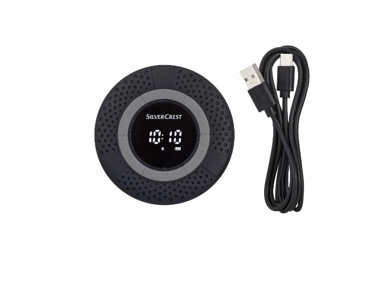Un haut-parleur Bluetooth rond noir de Silvercrest avec un câble USB.