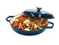 Cocotte en fonte bleue avec couvercle, remplie de légumes colorés coupés.