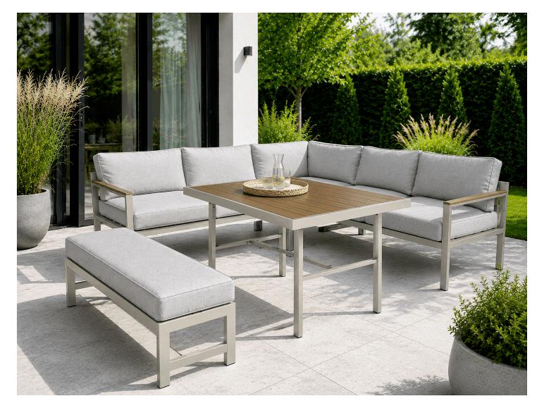 Ensemble de mobilier de patio extérieur avec canapé d'angle, banc et table basse sur une terrasse carrelée.