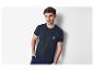 Modèle masculin portant un t-shirt foncé avec un imprimé palmier.