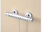 Mitigeur de douche thermostatique chromé avec raccord de tuyau, monté sur un mur beige.