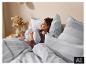Femme au lit avec du linge de lit à rayures LIVARNO home. [image générée par l'IA]