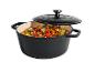 Cocotte en fonte noire avec couvercle, remplie de légumes colorés