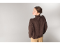 Femme en col roulé marron et pantalon beige, vue de dos