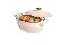 Cocotte ovale couleur crème avec couvercle, remplie de viande rôtie et de légumes.