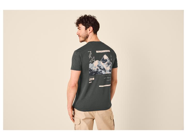 Homme de dos en T-shirt vert foncé avec imprimé montagne et short beige.