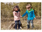 Deux enfants portant des vestes softshell rose et bleue dans la nature.