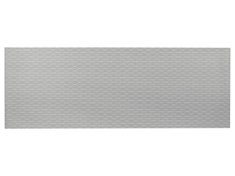 Tapis gris avec un motif de feuilles stylisées.