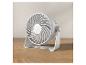 Petit ventilateur blanc sur une table en bois.