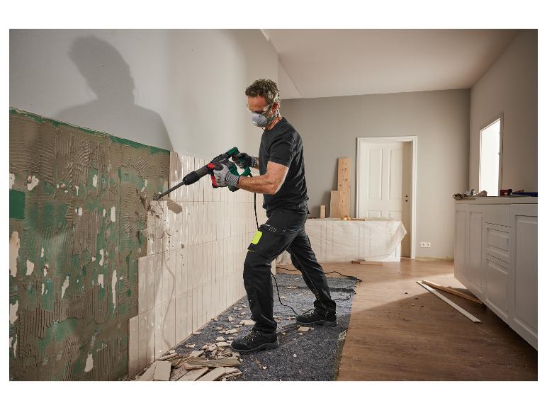 Un homme portant des lunettes de protection et un masque utilise un marteau démoliteur Parkside pour enlever des carreaux.