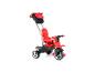 Un tricycle rouge avec une poignée pour les parents et un sac.