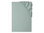 Drap-housse vert clair plié avec élastique visible sur le coin supérieur droit.