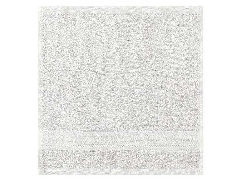 Une serviette blanche avec un bord brodé.