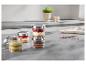 Desserts en bocaux sur un comptoir de cuisine, incluant fraise, pistache et chocolat.