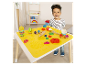 Un jeune enfant joue avec de la pâte à modeler Play-Doh sur une table avec un tapis intégré.