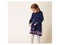 Une jeune fille porte une robe en tricot bleue à motif de coeurs et un sac assorti.
