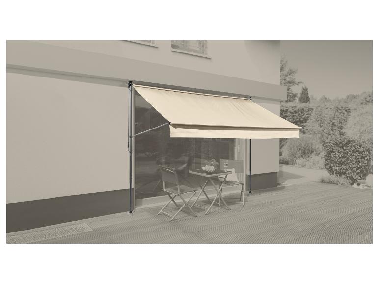 Store crème au-dessus d'un patio avec petite table et chaises, à côté d'une maison.